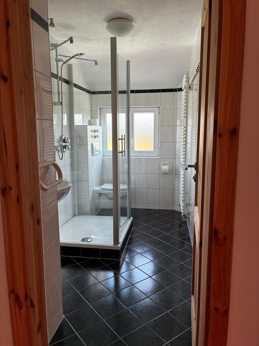 Bad mit großer Eckdusche, Fenster und Handtuchheizkörper